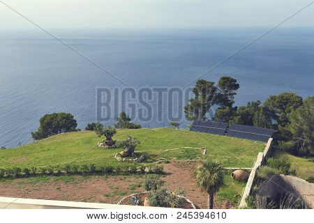 2018, 12 May, Banyalbufar, Majorca, Spain. Palm Trees An Earthenware Pots And Photo Solar Panels On 