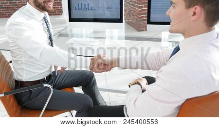 handshake colleagues sitting at your Desk