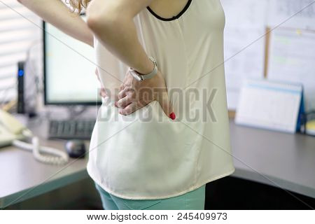 Close-up View Of A Office Worker Woman With Pain In Kidneys. Young Woman With Back Ache Clasping Her