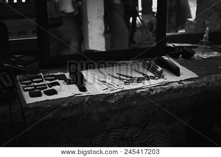 The Tools Of A Barber On The Desktop In Front Of The Mirror .black And White Photo Of Hairdresser To