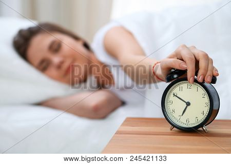 Sleepy Young Woman Stretching Hand To Ringing Alarm Willing Turn It Off. Early Wake Up, Not Getting 
