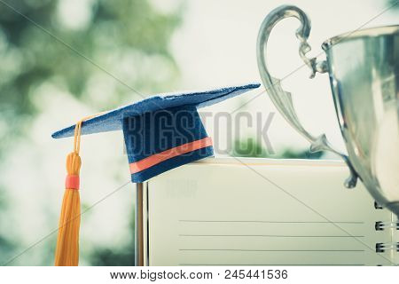 Graduation Cap On White Notebook With Champion Trophy Show Success In Education Learning Study Inter