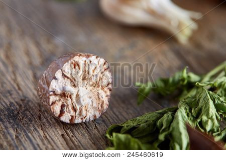Parsley And Nutmeg On Wooden Background, Close-up, Shallow Depth Of Field. Natural Organic Seasoning