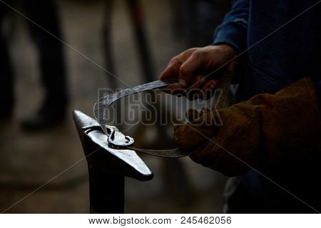 Close-up Of A Blacksmith's Hands Manipulating A Metal Piece Above His Forge, Selective Focus.