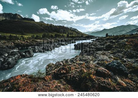 Wide-angle Shot Of A Cliffy Contrast Mountain Riverside Overgrown With Moss And Native Grasses, With