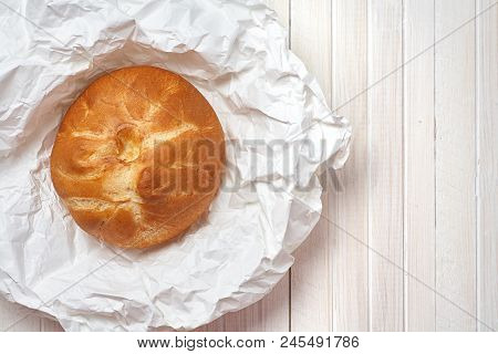 Fresh Homemade Bread On A Background Of White Paper And A White Wooden Background.