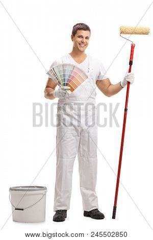 Full length portrait of a painter with a color swatch and a paint roller standing next to a bucket isolated on white background