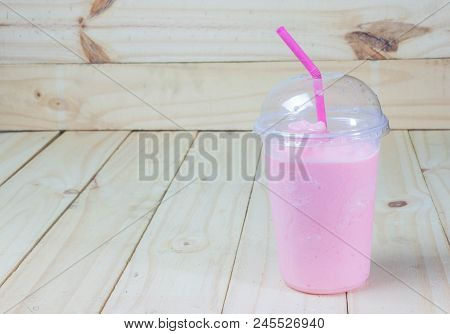 Strawberry Smoothie Yogurt In Plastic Glass On Wood Background