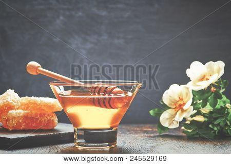 Honey With Wooden Honey Dipper On Wooden Table