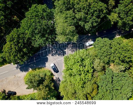 Aerial photo looking down above country road intersection car waiting to join fast road at junction