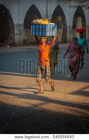Unidentified Man Carryng Weight On His Head - A Bucket Full Of Fresh Fish
