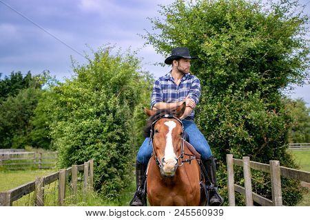 Good Looking, Hunky Cowboy Rides Horse With Boots, Chequered Shirt And Hat
