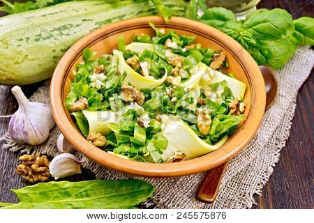 Salad Of Young Zucchini, Sorrel, Garlic And Nuts, Seasoned With Vegetable Oil In A Plate On Napkin O