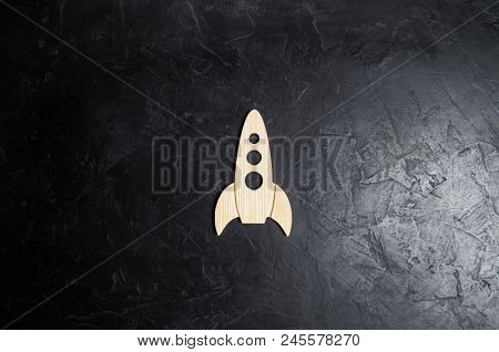 Wooden Space Rocket On A Dark Background. The Concept Of Space Travels, The Study Of Planets And Sta