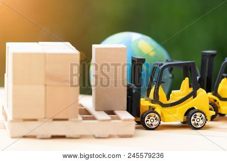 Mini Forklift Trucks Load Stack Of Cardboard Boxes On Wooden Pallet With Nature Background And Globe