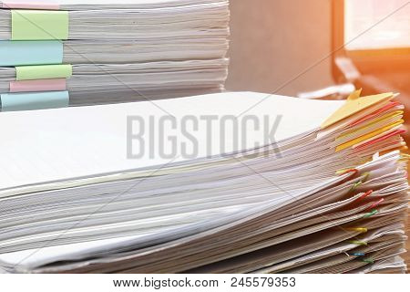 Close Up Pile Of Unfinished Paperwork Separated By Colorful Paper Clips On Office Desk Waiting To Be