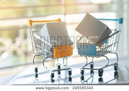 Cardboard Boxes In Trolley On Tablet. Consumers Can Buy Products Directly From Seller Over Internet 
