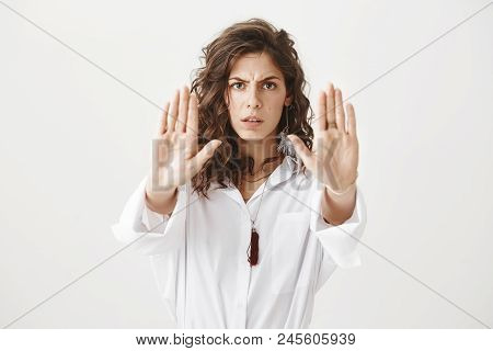 Worried And Confident Caucasian Woman Showing Stop Or Do Not Come Closer Gesture With Hands, Frownin
