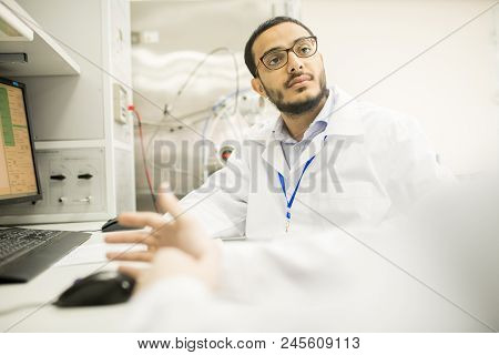 Group Of Highly Professional Technicians Wearing Lab Coats Gathered Together In Front Of Computer An