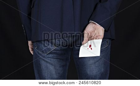 Man In Suit Holds Toilet Paper With Blood, Hemorrhoids, Black Background, Piles And Male