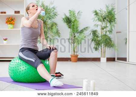 Young woman exercising with stability ball in gym