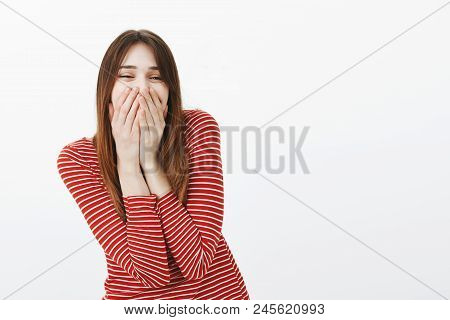 Portrait Of Friendly Happy Young Woman In Love, Standing Over Gray Background, Laughing From Joy And