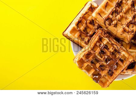 Belgian Waffles On A Plate Of Chopped Chocolate On A Yellow Background. Sweets, Dessert. Copy Space