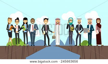 Businessman In Business Suit Shaking Hands Arabic Man Traditional Clothes Over Chasm Between Mountai
