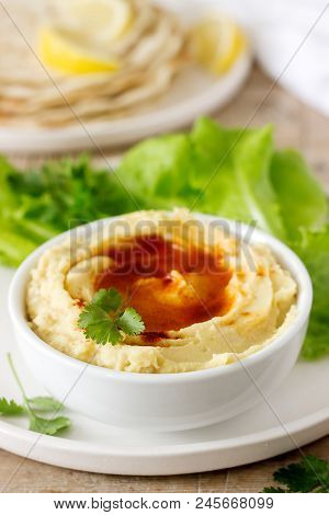 Hummus With Olive Oil And Paprika, Served With Pita, Lemon And Lettuce Leaves. Selective Focus.