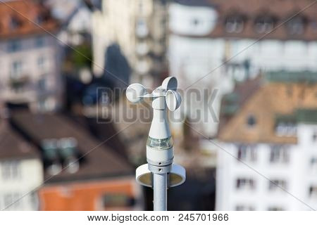White Anemometer Wind Gauge Within City With Houses