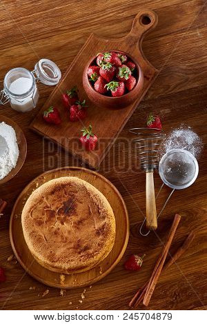 Top View Raw Ingredients For Cooking Strawberry Pie Or Cake On Wooden Table: Eggs, Sugar And Strawbe