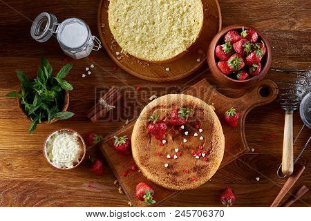 Top View Raw Ingredients For Cooking Strawberry Pie Or Cake On Wooden Table: Eggs, Sugar And Strawbe