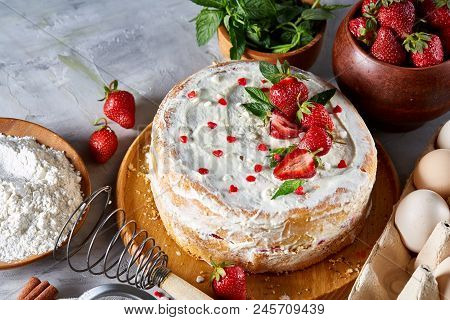 Strawberry Tart Covered With Whipped Sour Cream Surrounded By Organic Ingredients Over White Backgro