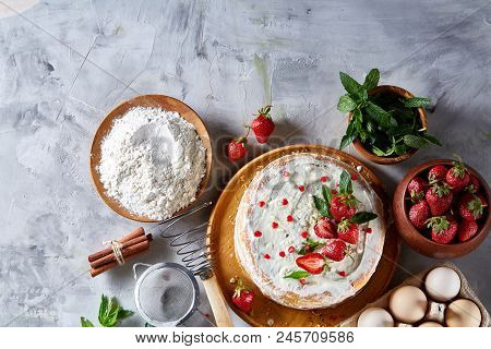 Strawberry Tart Covered With Whipped Sour Cream Surrounded By Organic Ingredients Over White Backgro