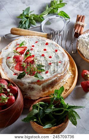 Strawberry Tart Covered With Whipped Sour Cream Surrounded By Organic Ingredients Over White Backgro