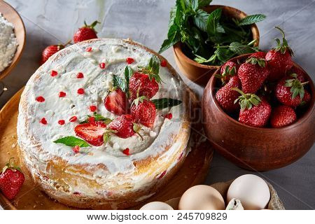 Strawberry Tart Covered With Whipped Sour Cream Surrounded By Organic Ingredients Over White Backgro