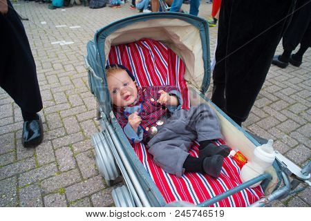Urk, Netherlands - May 19, 2018: Unknown Baby In An Vintage Stroller In Traditional Costume On The U