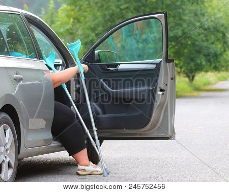 Disabled woman upgoing from a car. Transportation and travel for handicapped people.