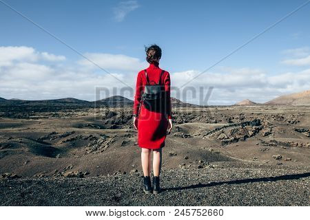 Back View Of Traveler Woman Enjoying Unique Volcanic Landscapes Of Timanfaya National Park, Lanzarot
