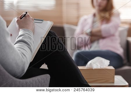 Back View Of Psychotherapist Writing Notes, Assessing Patient's Health And Giving Diagnosis To A Wom