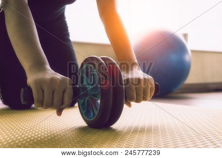 Hand Women Does The Exercises With Ab Wheel In The Gym. Sports Concept, Fat Burning And A Healthy Li