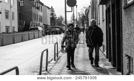 Asian Senior Couple Walking In Rekjavik, Iceland Black And White
