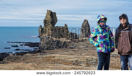 Asian Senior Couple Travel Photo With Iceland Pennisula Rock Landmark