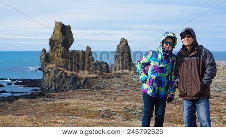 Asian Senior Couple Travel Photo With Iceland Pennisula Rock Landmark