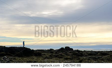 Man Sihouette On Icealnd Rock Formatoin Beautiful Golden Sky