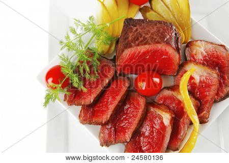 半生的牛肉肉与蔬菜在白板上