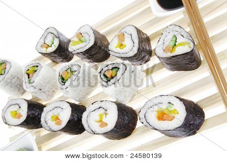 Rollen Sie mit Gurke, Frischkäse mit rohen Thunfisch und Lachs im Inneren. auf dem hölzernen Rost. Wh isoliert