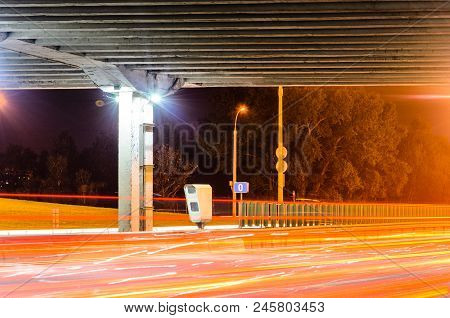 Stationary Car Speed Radar Near A Highway Road. Night Road Traffic Background