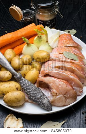 Fish Raw Snapper With Herb Spices For Fish In Glass Jar, Pepper, Bay Leaf, Celery On Dark Wood Backg