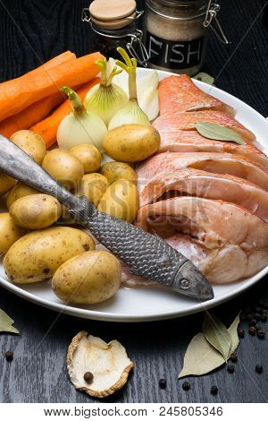 Fish Raw Snapper With Herb Spices For Fish In Glass Jar, Pepper, Bay Leaf, Celery On Dark Wood Backg